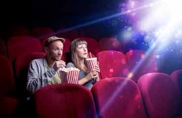 Obraz premium Romantic couple cuddling and watching the miraculous part of the film