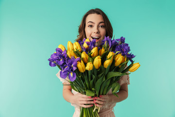 Portrait of a happy young girl in dress holding big bouquet