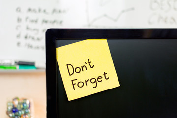 reminder yellow sticker on the monitor with text Don't Forget