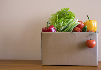 cardboard box with fresh vegetables on the table