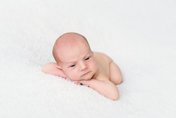Newborn baby boy lying on a white blanket