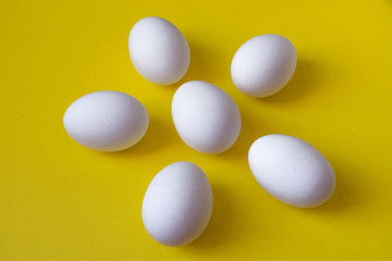 White eggs in the form of a spring flower on a yellow background