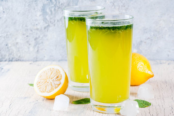Indian traditional drink, Mint Masala Soda cocktail with lemon, mint and spices, light concrete background, copy space