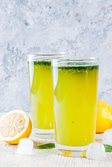 Indian traditional drink, Mint Masala Soda cocktail with lemon, mint and spices, light concrete background, copy space