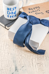 Father's Day gift concept, greeting card background, gift box, tie decoration, mug with inscription...