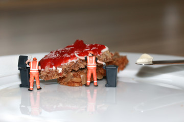 Zwei Miniaturfiguren Müllmänner entsorgen nicht aufgegessenes Marmeladenbrot 
