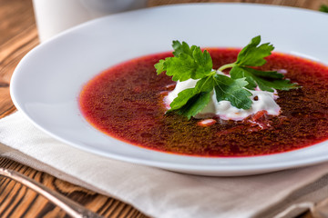 Borscht on a wooden table with garlic