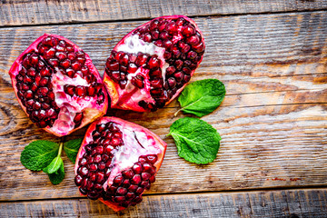 sliced pomegranate on wooden background top view
