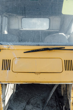 Old car close to a black gravel pile at a quarry with broken car body