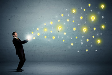 Fototapeta premium Caucasian businessman holding lightbulbs which are flying out from his hands