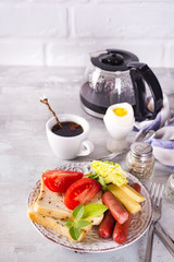 English breakfast. Fried eggs, sausages, toasts, tomatoes on stone table.