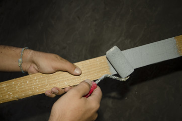 Mano de hombre pintando con un rodillo una madera