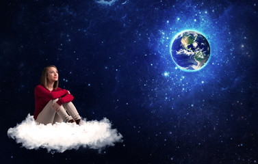 Fototapeta na wymiar Caucasian woman sitting on a white fluffy cloud sitting and wondering at planet earth
