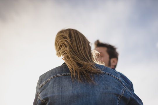 Back view of a womans hair blowing by the wind