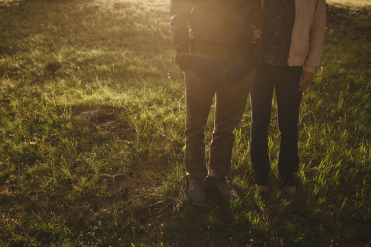 Front view of a couple embracing in the forest at sunset