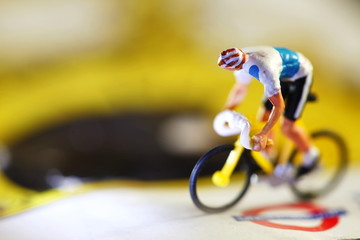 Miniature model of cyclist on bicycle scene.