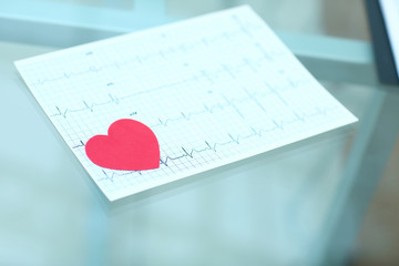 stethoscope,cardiogram and red paper heart on the table