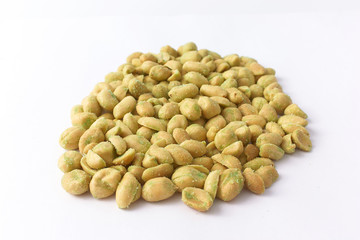 Salted peanuts with green sprinkling on a white background.