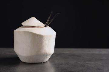 Fresh coconut drink in nut on table against black background © New Africa
