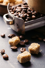 Black fried coffee beans on dark textured background