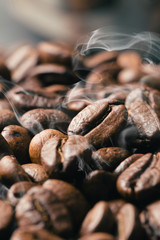 Black fried coffee beans on dark textured background