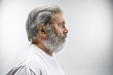The senior attractive man looking suprised isolated on white