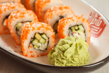 Close up wasabi and sushi rolls - Uramaki California on the plate. Japanese cuisine