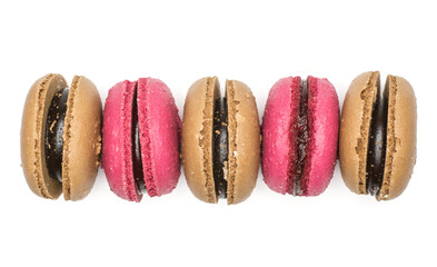 Five French macarons (chocolate, raspberry) top view isolated on white background.