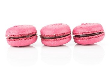 Pink French macarons three with raspberry jam in row isolated on white background.