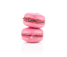 Two pink French macarons with raspberry jam isolated on white background.