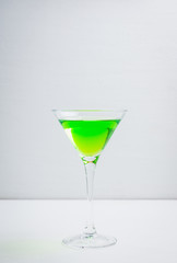 Apple martini cocktail on the white rustic background. Selective focus.