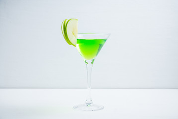 Apple martini cocktail on the white rustic background. Selective focus.