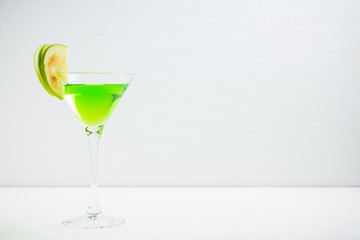 Apple martini cocktail on the white rustic background. Selective focus.