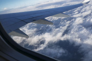 Fototapeta na wymiar Airplane wing view from window seat above bridge