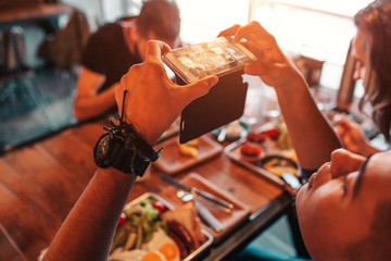 Young arabian man takes a picture of his food for social network. Internet addiction concept. Breakfast in cafe.