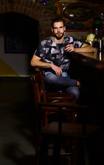 Macho in bar drinks shot and liqueur. Party concept.