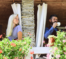 Girl with blond hair and bearded guy on cafe background.