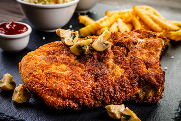 Fried pork chop, French fries and vegetable salad