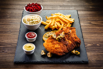 Fried pork chop, French fries and vegetable salad