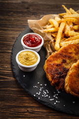 Fried pork chop, French fries and vegetable salad