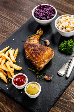 Grilled chicken legs with French fries and vegetables