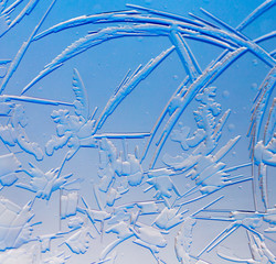 Blue drawings on the glass in the frost