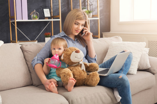 Young mother working and spending time with baby