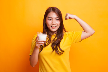 Healthy Asian woman drinking a glass of milk in yellow dress