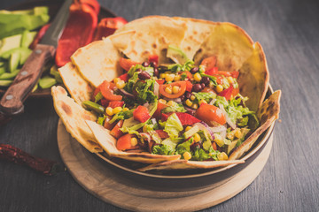 Traditional Mexican vegetarian taco salad with avocado, corn, pepper, tomatoes and beans
