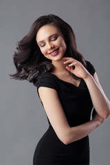 Fototapeta premium Young beautiful woman with fashion makeup, in black dress