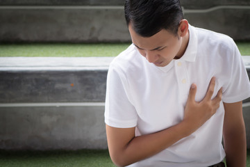 man with heart attack; sick asian man suffering from heart attack or seizure; young adult asian man...