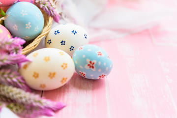 Fototapeta na wymiar Happy easter! Colorful of Easter eggs in nest with paper star, flower and Feather on pastel color bright pink and white wooden background.