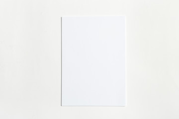 White business card on wooden table. Blank portrait A4.