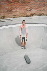 high angle view of handsome skater standing in pool at skatepark